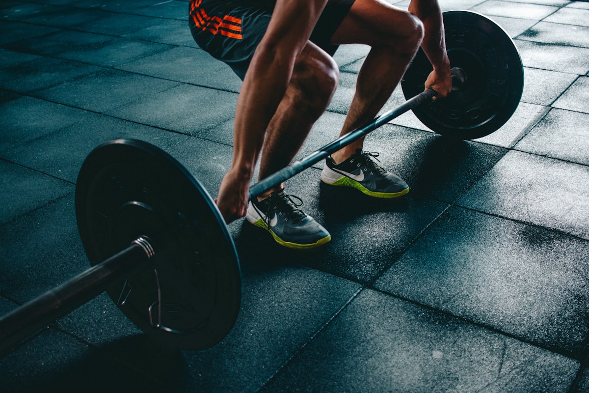 Atleta executando levantamento terra com barra na academia
